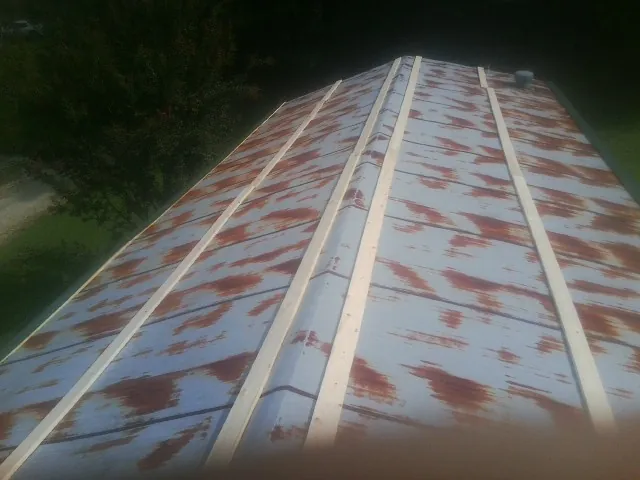 Rusted metal roof panels with new wood purlins before replacement — Storm Damage Roof Repair in Green Bay by Roofing Brothers