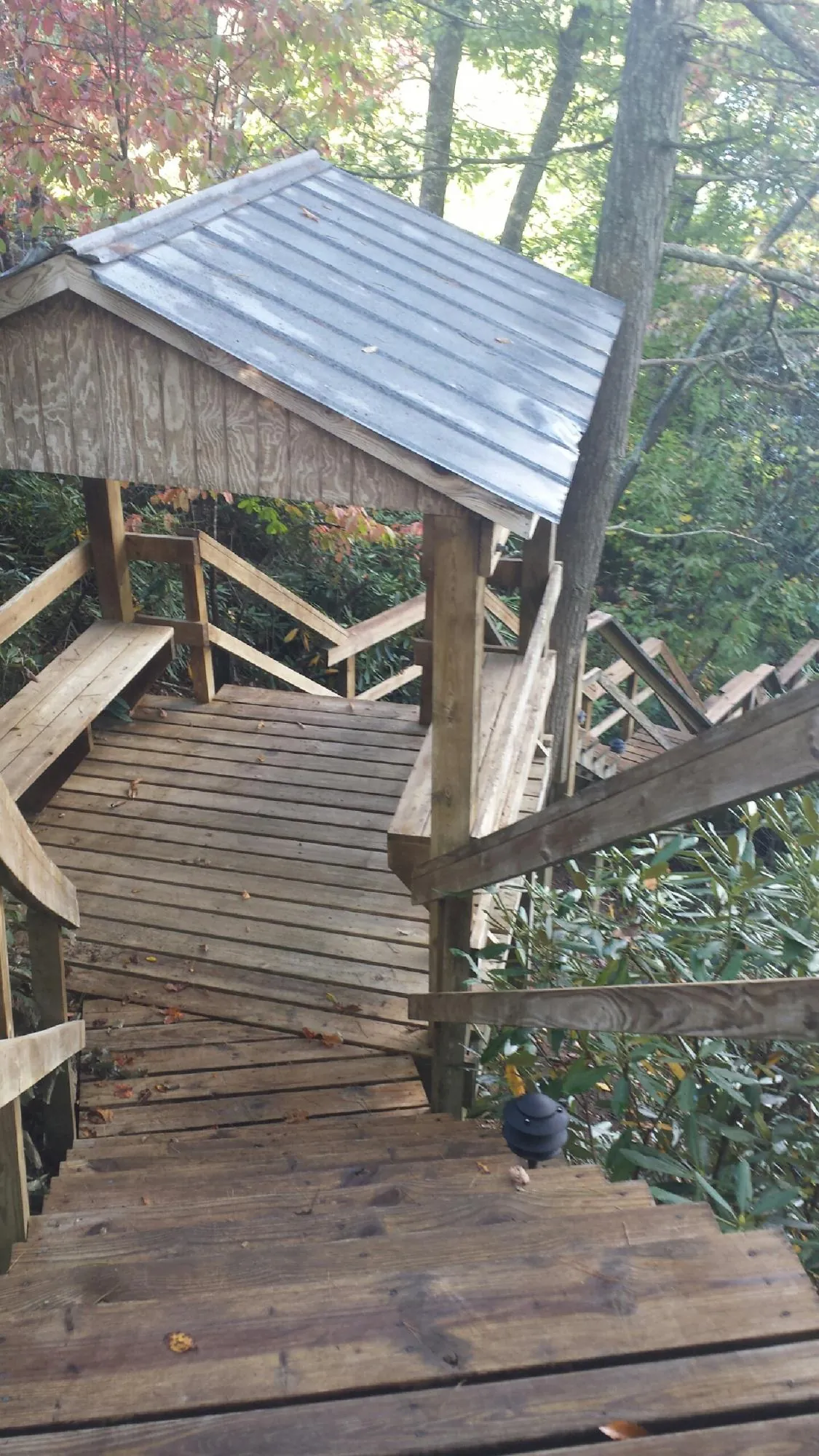 Metal roofed shelter over wooden steps on a wooded walkway — Skylight Repair & Installation work by our crew in Green Bay