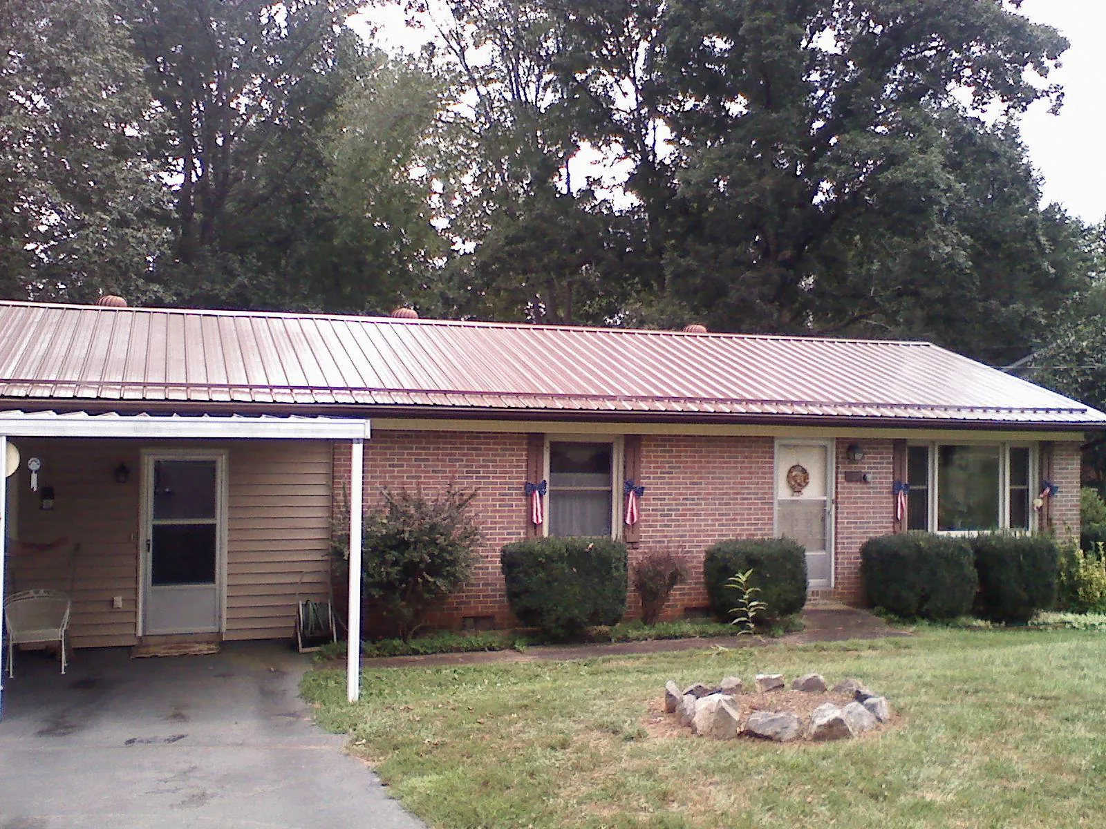 Bronze metal roof and carport on a brick ranch home — Roof Repair work by our crew in Green Bay